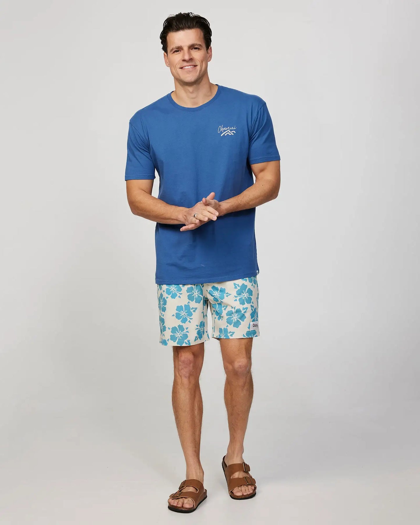 Full body front view of a male model wearing the Okanui Mens Waterworld stretch swim short in Stone Aqua