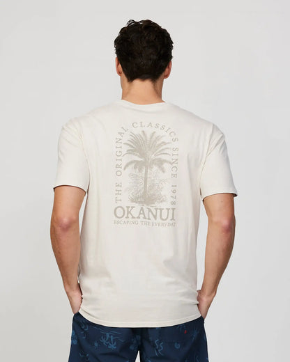 Back view of a male model wearing the Okanui Mens Barrel Tee T-shirt in Stone