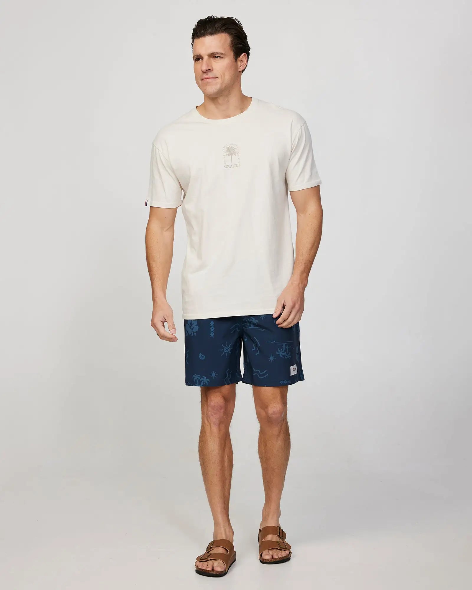 Full body front view of a male model wearing the Okanui Mens Barrel Tee T-shirt in Stone