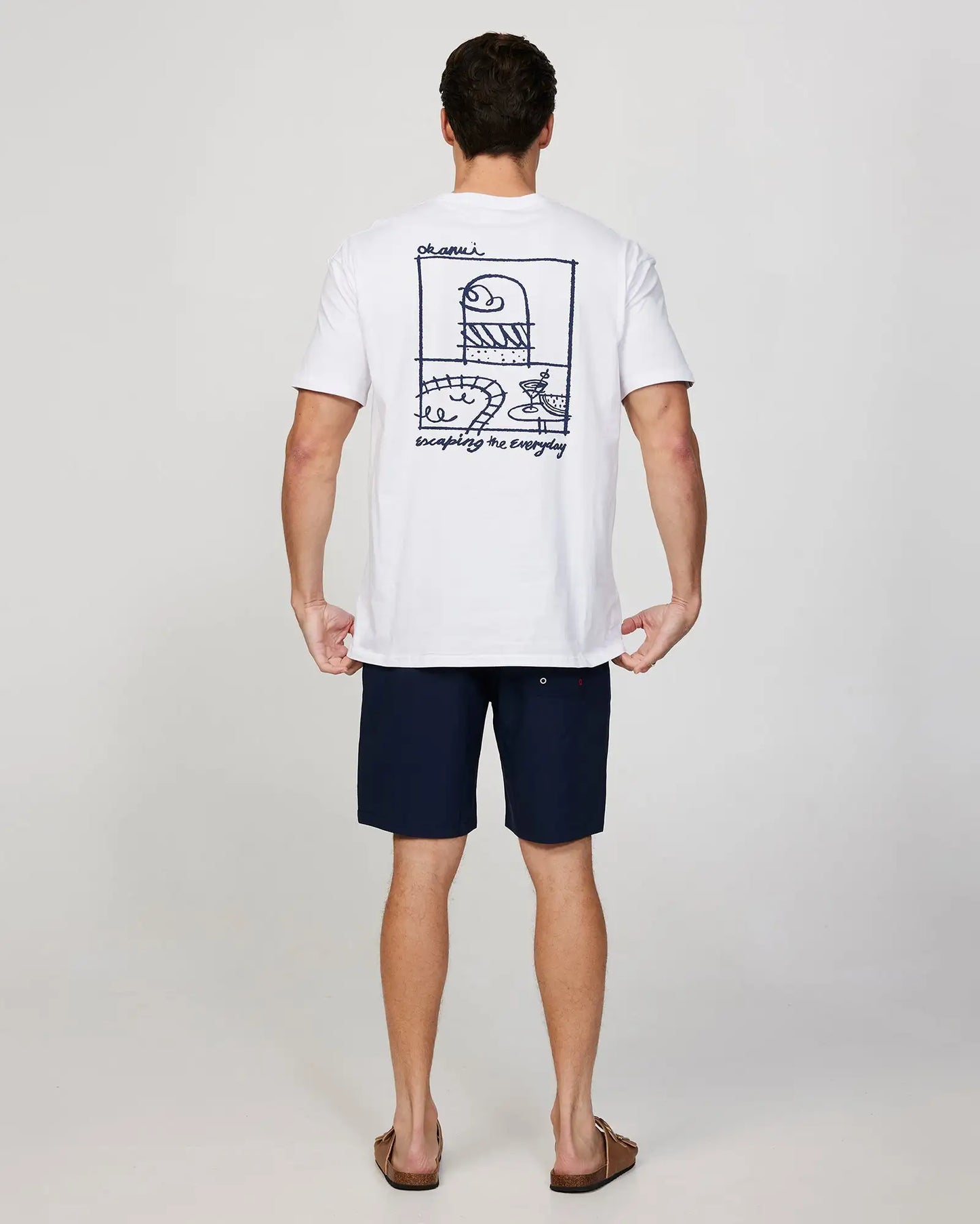 Full body back view of a male model wearing the Okanui Cruise Tee T-shirt in White