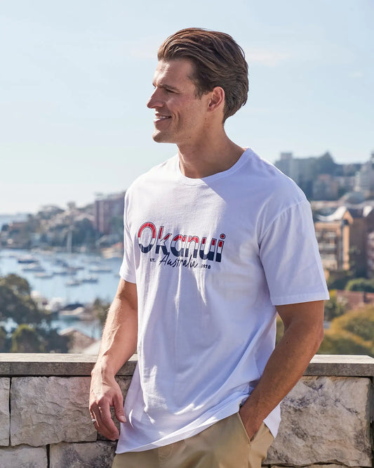 Closeup left side view of a male model wearing the Okanui Mens T-Shirt Destination Tee in White