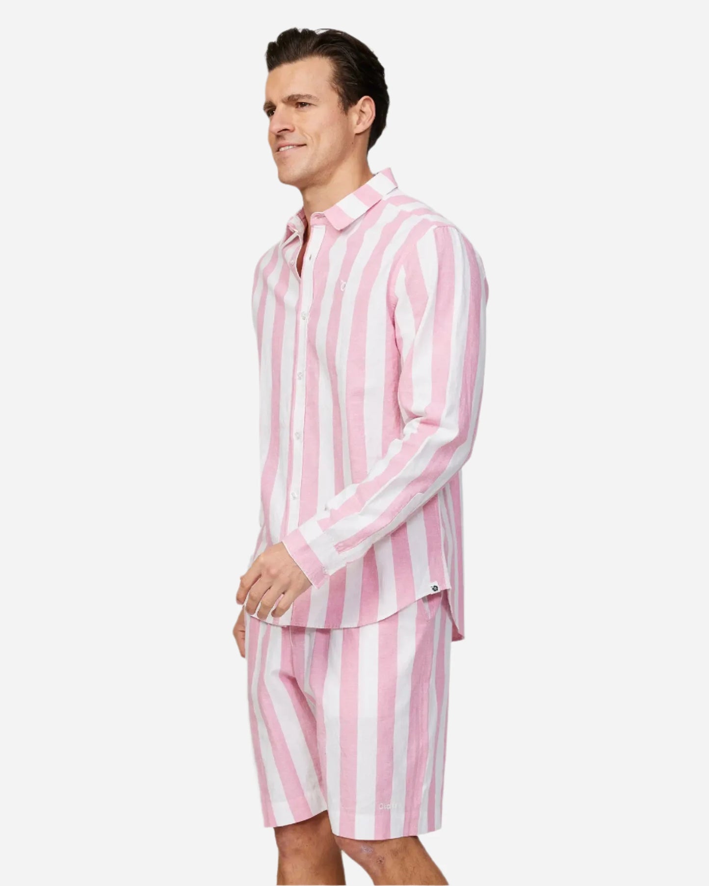 Full body left side view of a male model wearing the Okanui Mens Classic Stripe Walk short in Pink paired with a long sleeve shirt in stripe pink