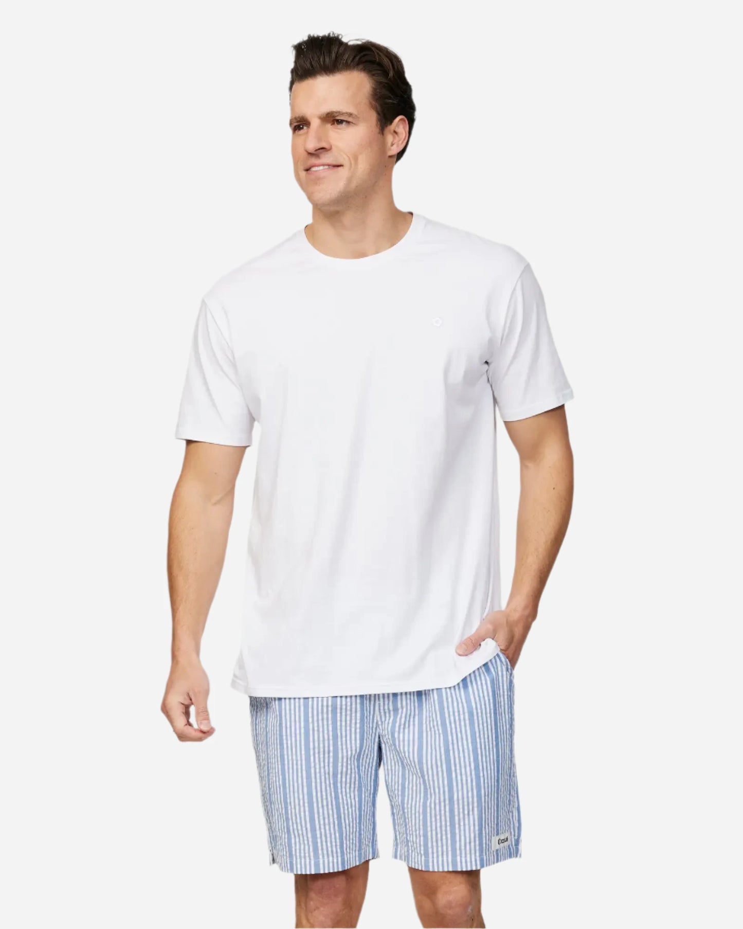 Front view of a male model with his hand on the pocket wearing the Okanui Mens Starboard walk short in Blue Stripes paired with a white shirt