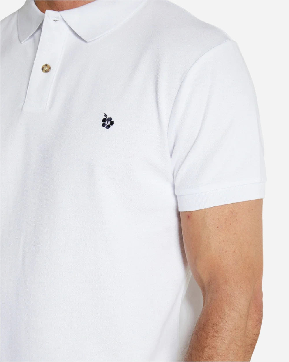 A close up look of the Okanui Classic Polo Shirt for men in white color featuring the Okanui logo embroidery.