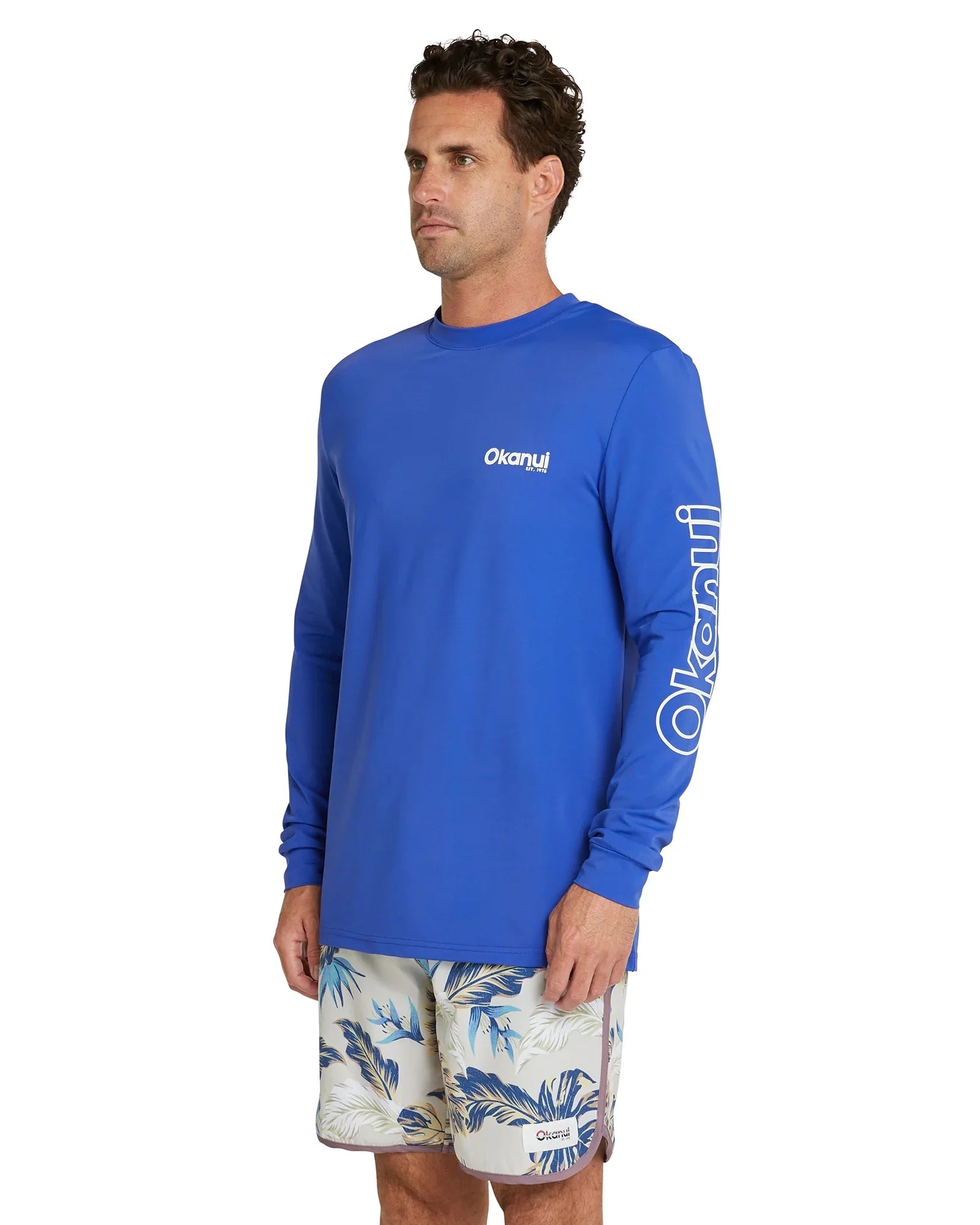 The Okanui Men's summer long sleeve rash shirt in royal blue with white print on sleeves.