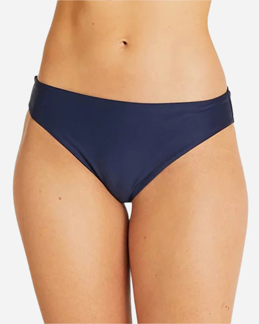 Close up view of a female model wearing the Okanui womens brief style bikini bottom swimsuit in Navy 