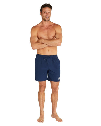 A male model smiling wearing the Okanui Classic Plain Swimshorts for men.