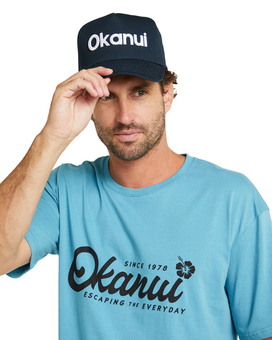 Front view of a male model wearing the Okanui All day snapback trucker cap for mens in Navy color